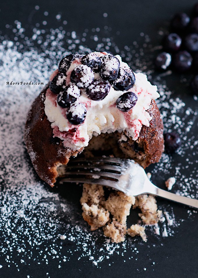 Moist Banana Blueberry Mini Bundt Cakes made from scratch, topped with some whipped cream and fresh blueberries are so good. No better way to use those over ripe bananas no one wants to touch anymore.
