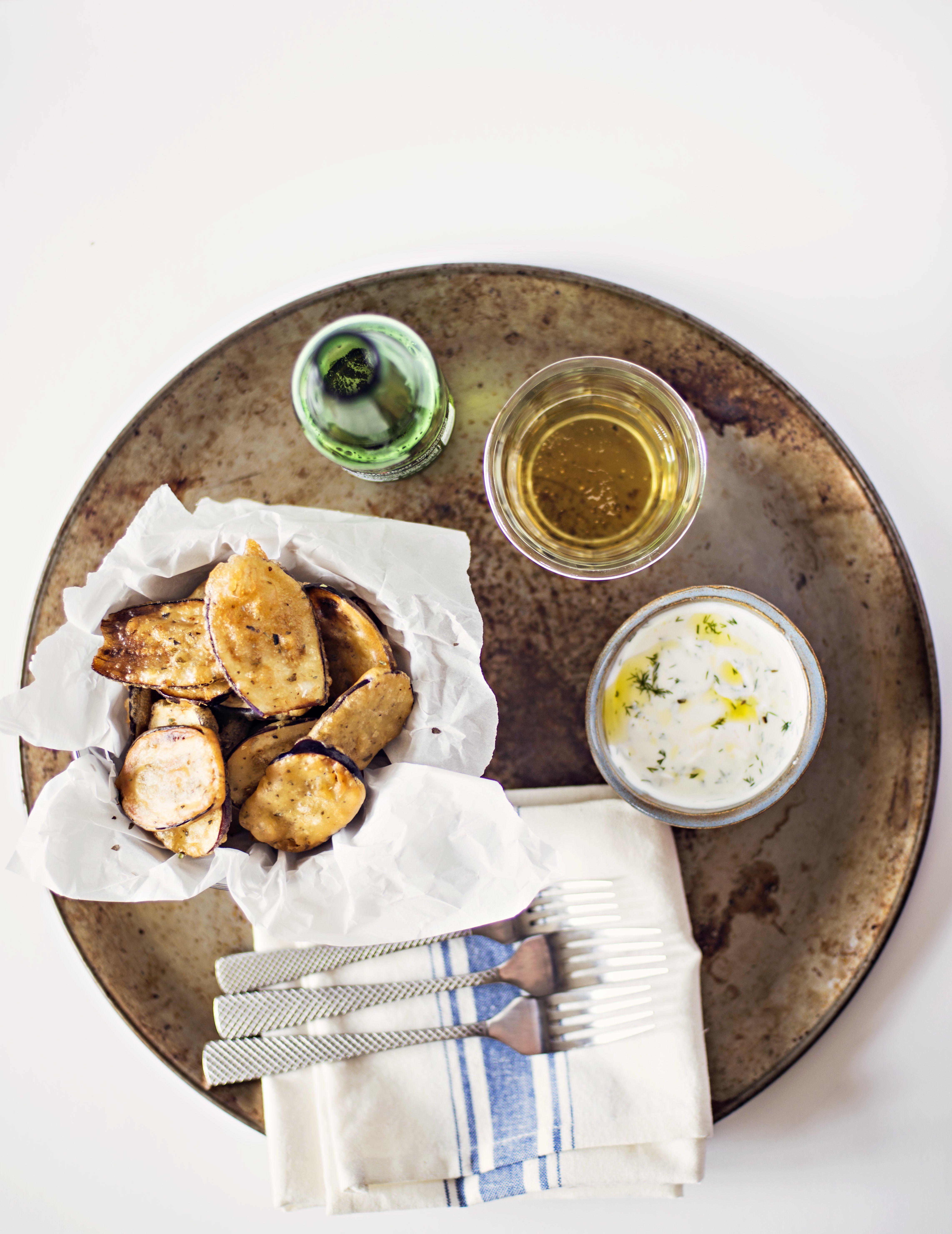 Fried eggplant appetizer served with Greek Dill Yogurt on a platter