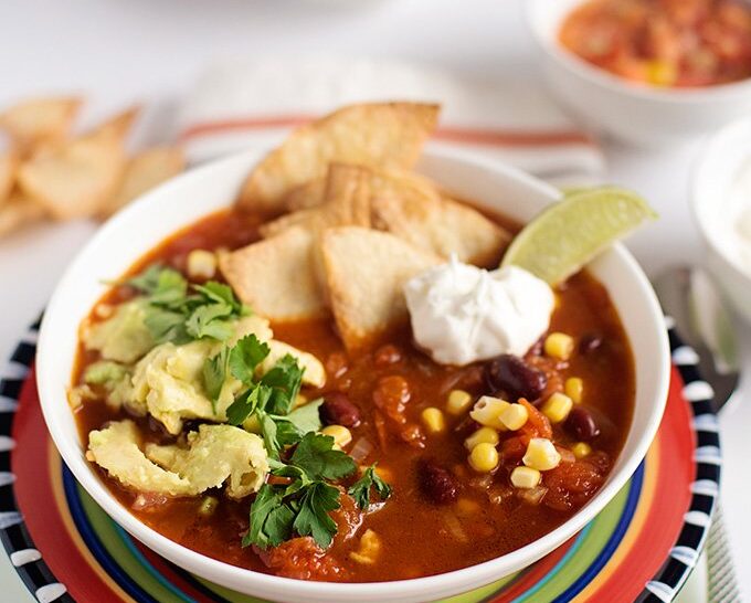 Mexican tortilla soup with avocado and tomato salsa