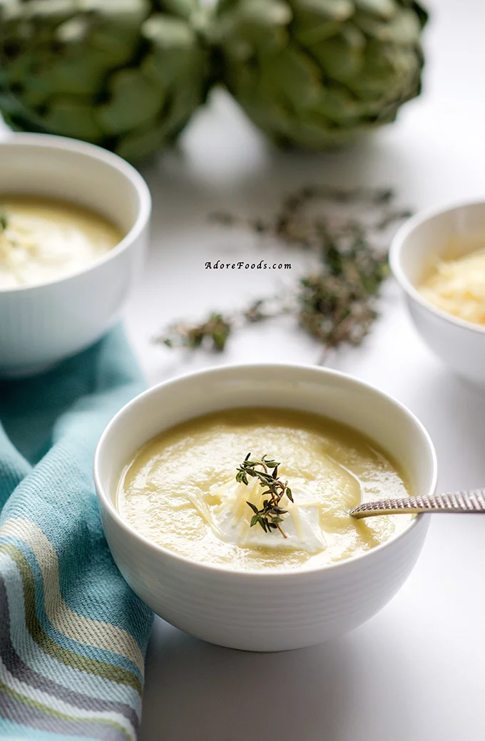 Perfect spring recipe! Creamy artichoke soup served with parmesan, sour cream and fresh thyme! In less than 30 minutes, you'll ladle this soup into your bowls!
